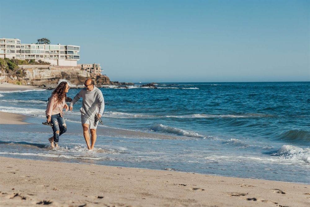 Couple strolling along a sunny beach by the ocean