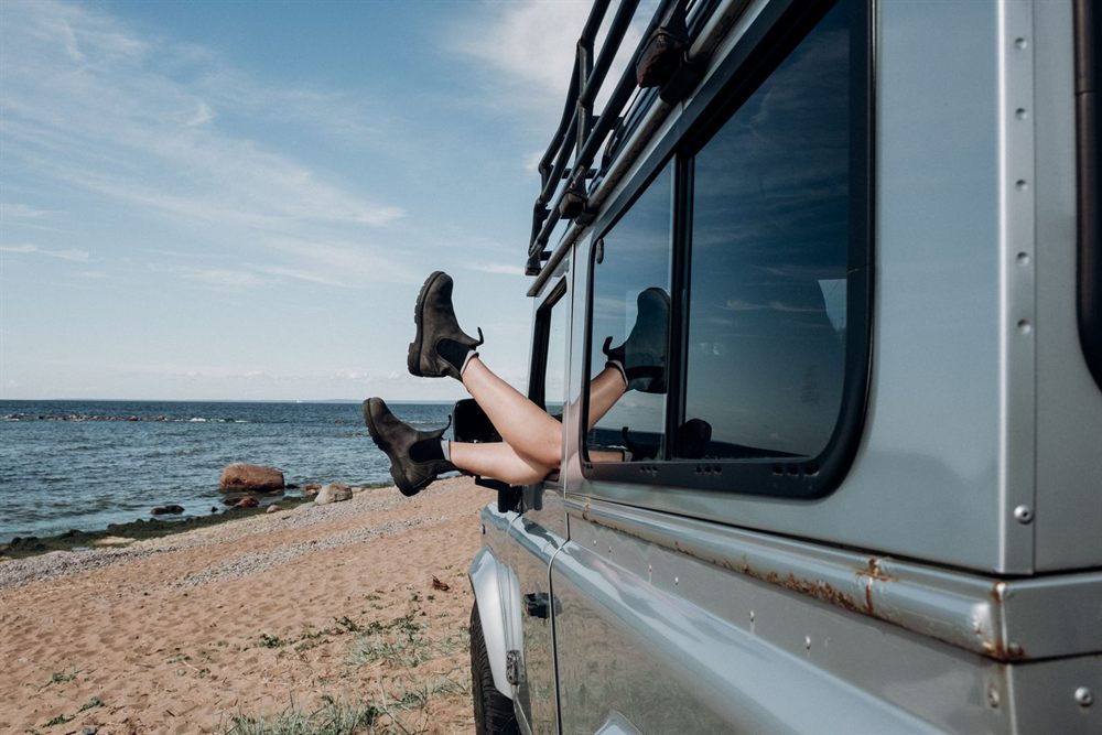 Bare feet out of a car window beside a beach on a spontaneous trip
