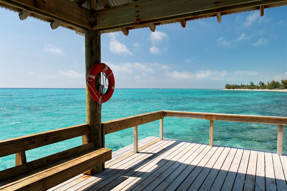 Wooden dock with a lifebuoy over turquoise island water