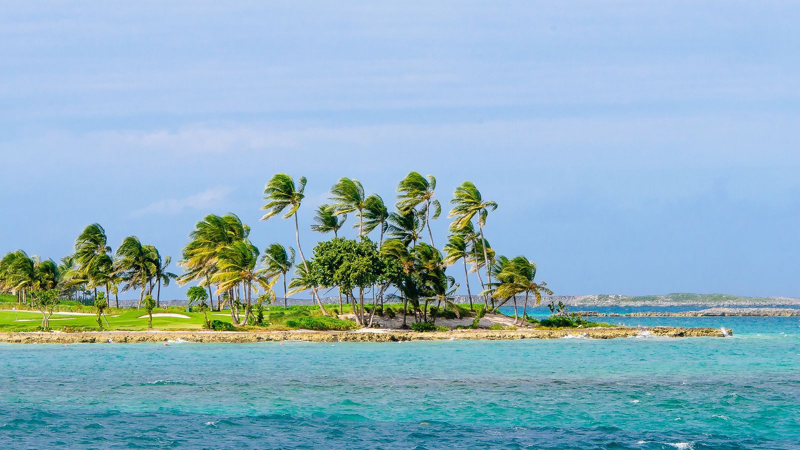 Palm-covered tropical island in clear blue water, the kind of stop weekend cruises make